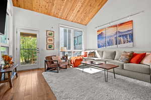 Living area featuring a vaulted wooden ceiling, light wood-type flooring, and plenty of natural light