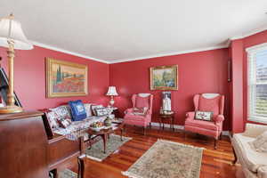 Living room featuring hardwood / wood-style flooring and crown molding