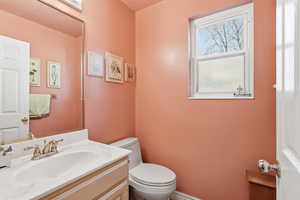 Half bathroom featuring vanity and toilet