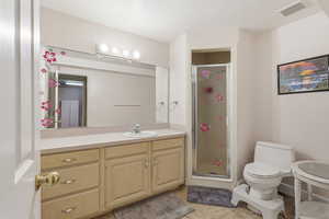 Full bath with a stall shower, vanity, and light tile patterned floors