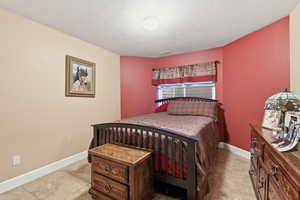 Bedroom featuring baseboards and a textured ceiling