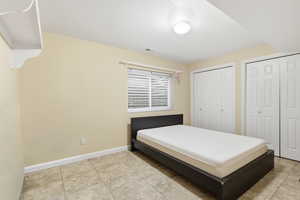Bedroom with multiple closets and baseboards