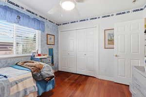 Bedroom featuring dark wood finished floors, a closet, and a ceiling fan