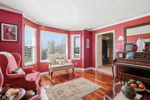 Living area featuring light wood-style floors, crown molding, and recessed lighting