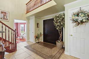 Entrance foyer featuring ornamental molding, a high ceiling, and light tile patterned floors