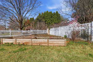 Fenced backyard featuring a vegetable garden