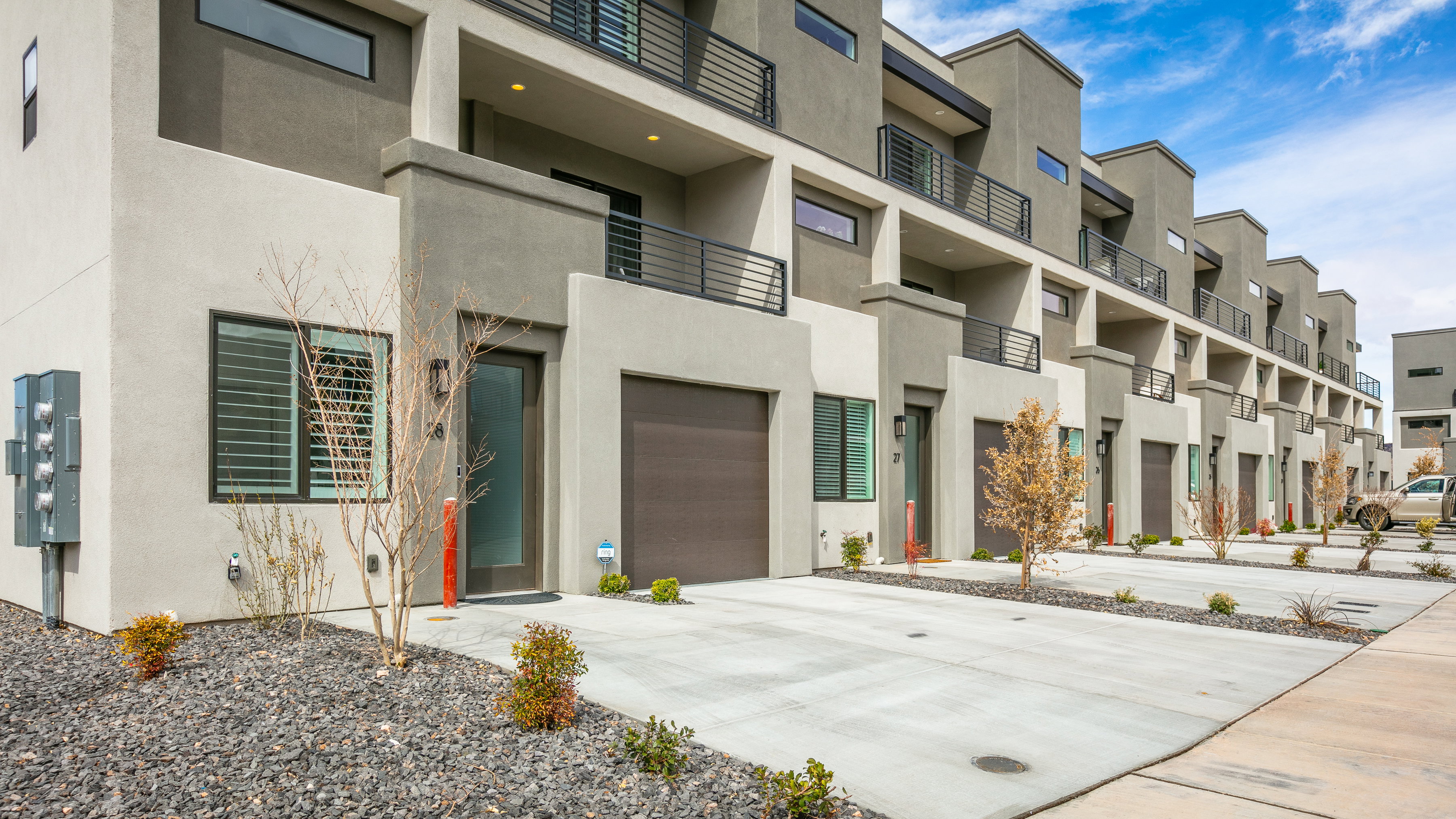 View of property featuring an attached garage and concrete driveway