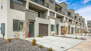 View of property featuring an attached garage and concrete driveway