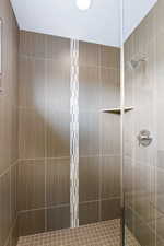 Bathroom with a shower stall and a textured ceiling