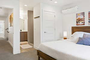 Bedroom with recessed lighting, light carpet, and ensuite bath