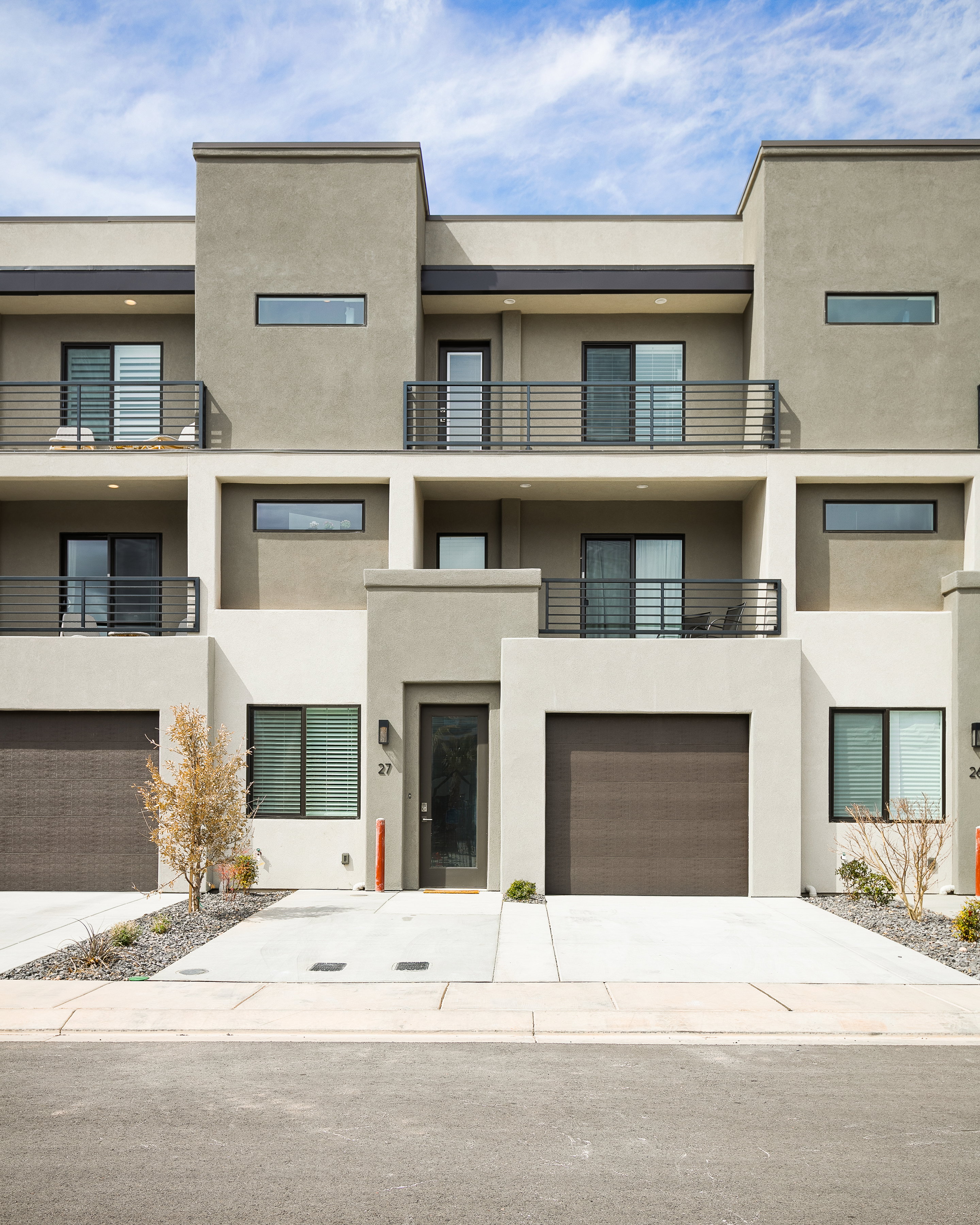 View of apartment building / complex featuring driveway and a garage
