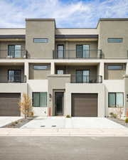 View of apartment building / complex featuring driveway and a garage