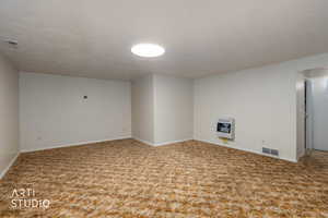 Finished basement featuring carpet floors and heating unit