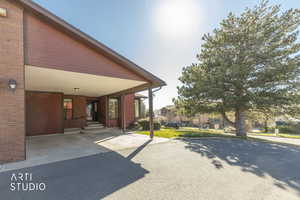 View of patio featuring an attached carport, asphalt driveway, and entry steps