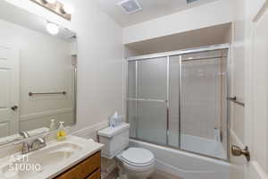 Bathroom featuring vanity and enclosed tub / shower combo