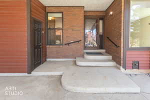 Entrance to property with brick siding