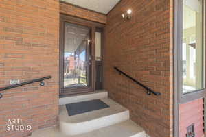 Doorway to property with brick siding