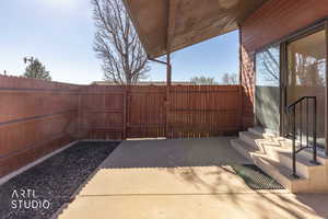 Fenced backyard featuring a gate and a patio area