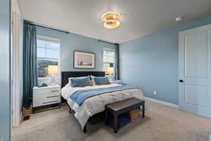Bedroom with light carpet and a textured ceiling