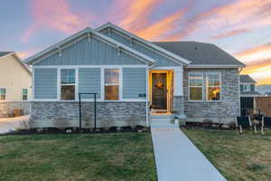 View of front of home featuring stone siding, board and batten siding, and a shingled roof