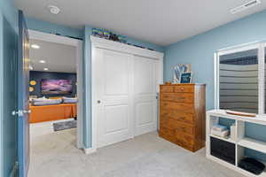 Bedroom featuring light carpet and a closet