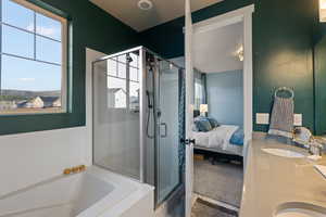 Bathroom with ensuite bathroom, vanity, a bath, and a shower stall