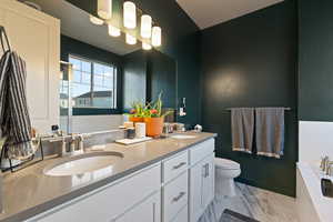 Full bath with double vanity and a garden tub