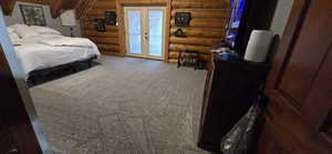 Bedroom featuring log walls, light carpet, access to outside, and french doors