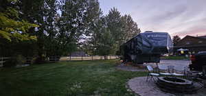 Yard at dusk with a fire pit and a patio area