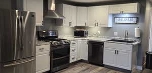 Kitchen with stainless steel appliances, white cabinetry, dark wood-style floors, and light stone countertops
