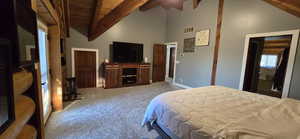 Bedroom featuring light carpet, a high wooden beamed ceiling, and a ceiling fan
