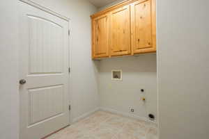 Laundry room with hookup for a gas dryer, washer hookup, cabinet space, and electric dryer hookup