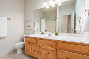 Full bath featuring vanity, a shower with shower curtain, and light tile patterned floors