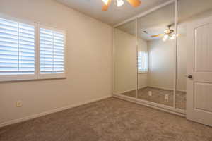 Unfurnished bedroom with carpet floors, a ceiling fan, and a closet