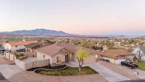 Ranch-style home with stone siding, concrete driveway, a garage, a residential view, and stucco siding
