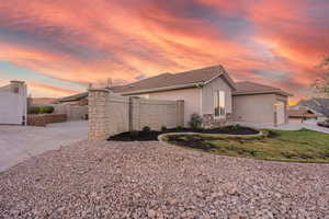 View of side of property featuring stucco siding, stone siding, and a tiled roof