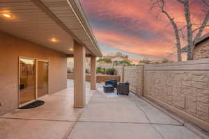 Patio terrace at dusk featuring a patio area and a fenced backyard
