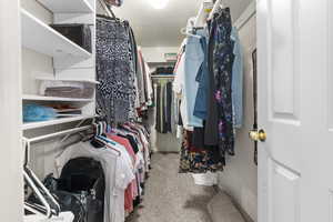 Walk in closet with light carpet