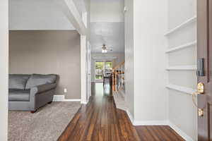Entryway with dark wood-style flooring and stairway