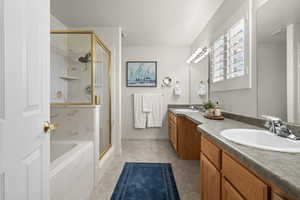 Bathroom featuring double vanity, a marble finish shower, a garden tub, and a textured ceiling