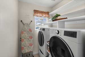 Laundry room featuring washing machine and dryer and baseboards