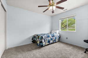 Bedroom with wainscoting, a ceiling fan, carpet flooring, and a textured ceiling