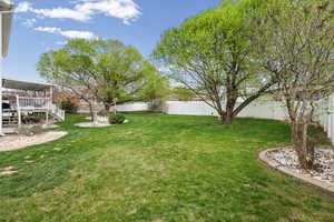Fenced backyard featuring a deck