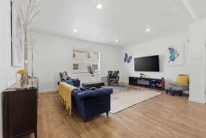 Living area with light wood-style flooring and recessed lighting