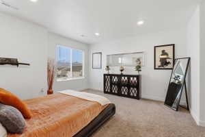 Bedroom with light colored carpet and recessed lighting