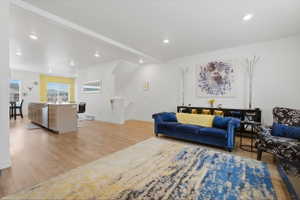 Living area featuring light wood finished floors, recessed lighting, and beamed ceiling
