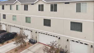 View of garage, concrete driveway, and stucco siding