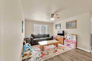 Living area featuring a ceiling fan and light wood-style flooring