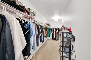 Primary Bedroom huge Walk in closet with light colored carpet