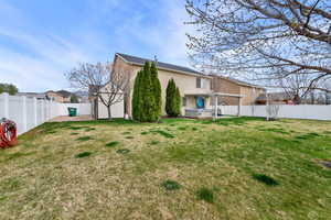 Back of house with a hot tub, a fenced backyard, and stucco siding